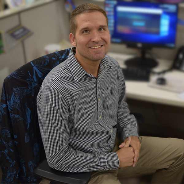 Andy Zipay sitting at computer smiling