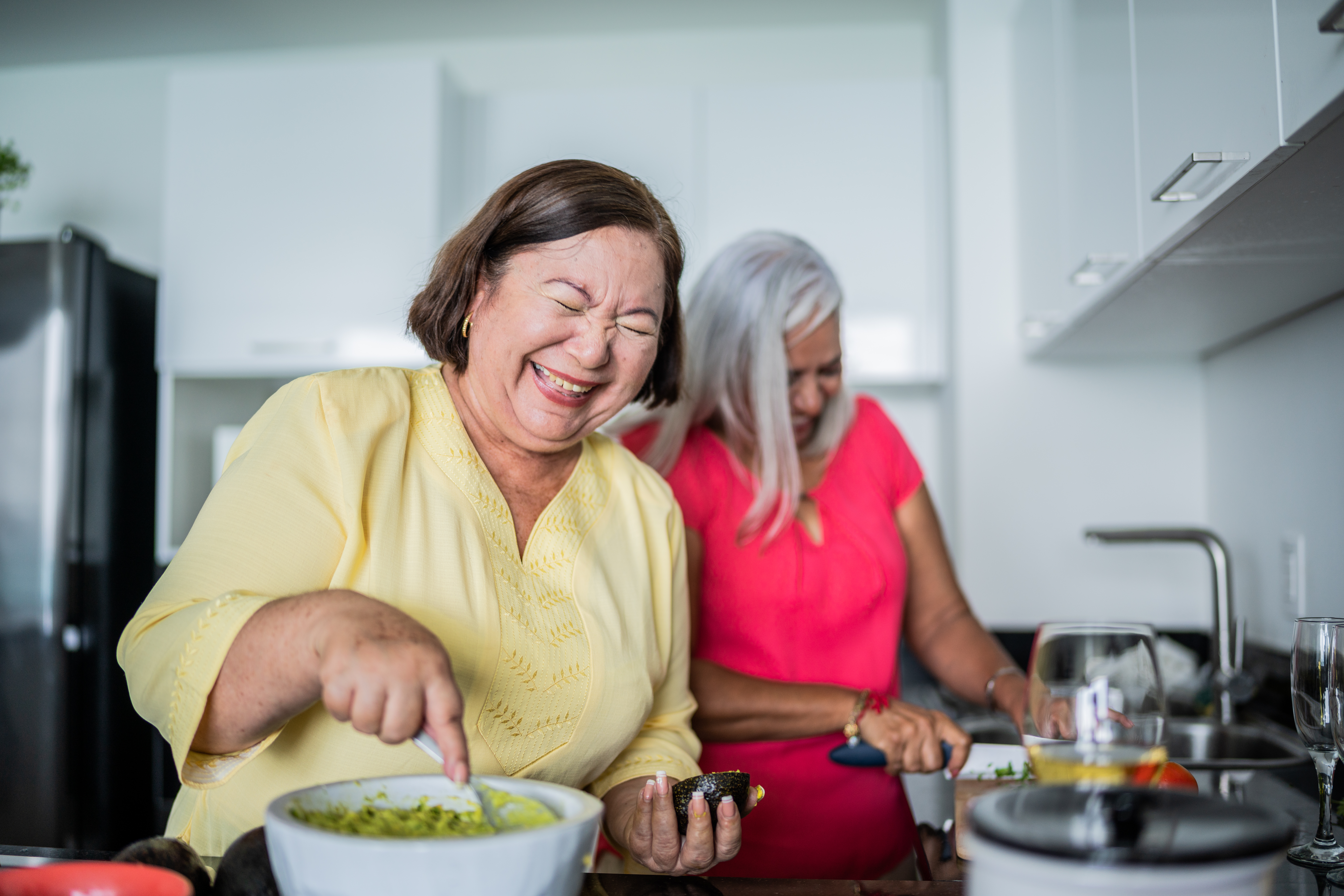 Two people cooking and laughing together.