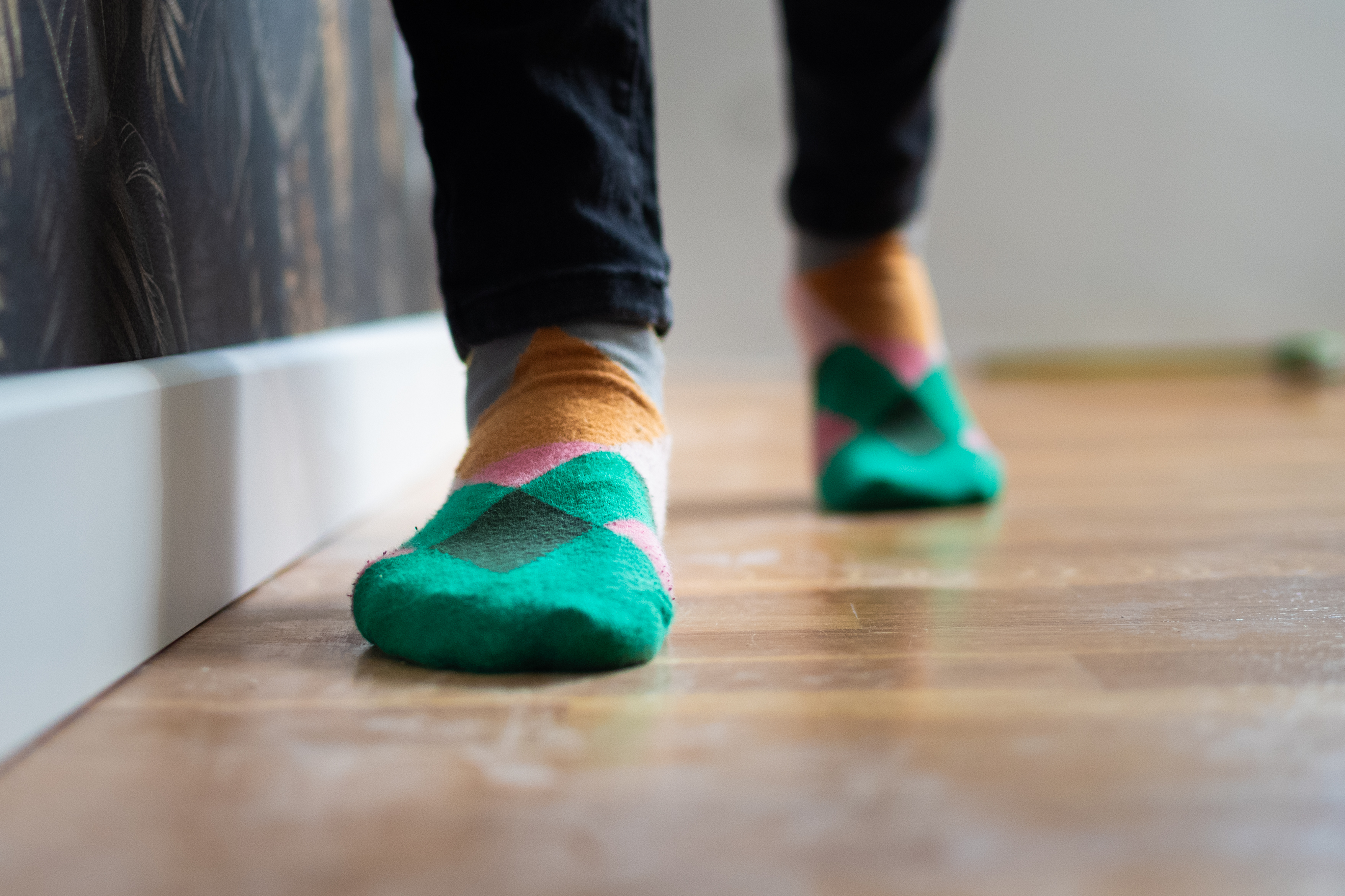 Feet in green and orange argyle socks walking toward the camera.