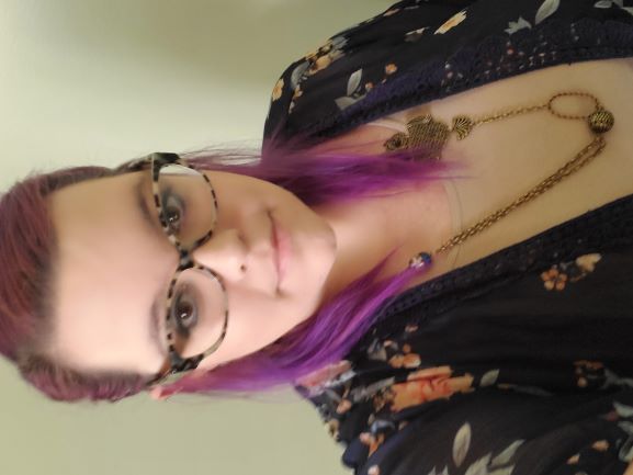 Photo of Rachel Levin with purple hair and glasses