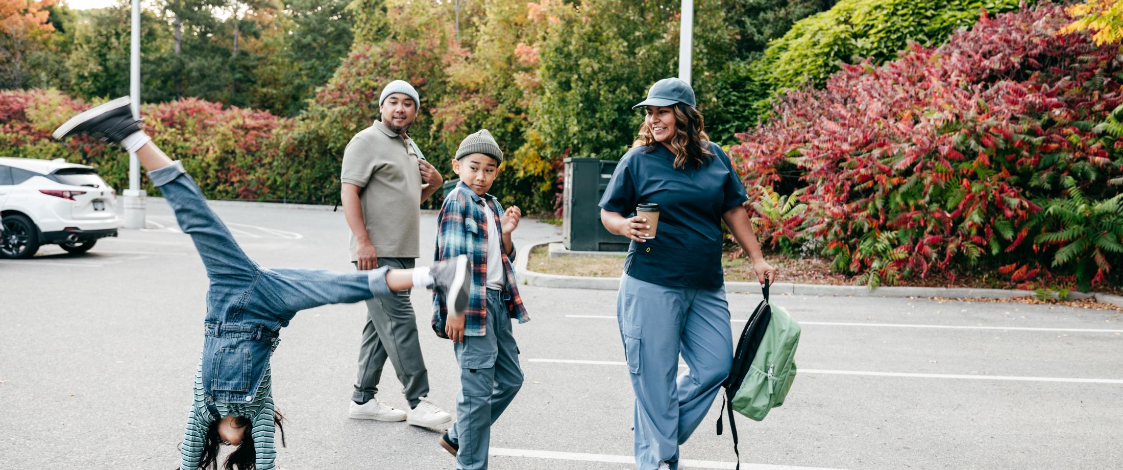 Family walking as child does cartwheel.