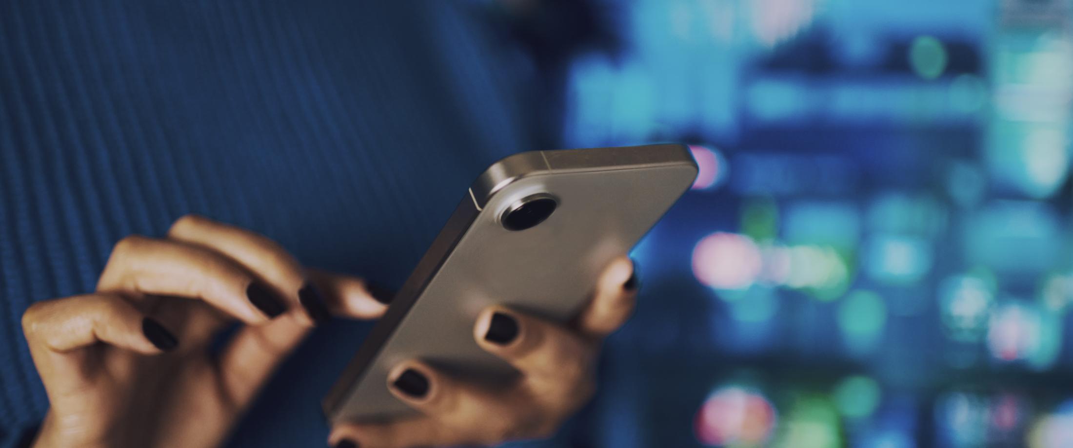 A person's hands holding a cell phone and dialing.