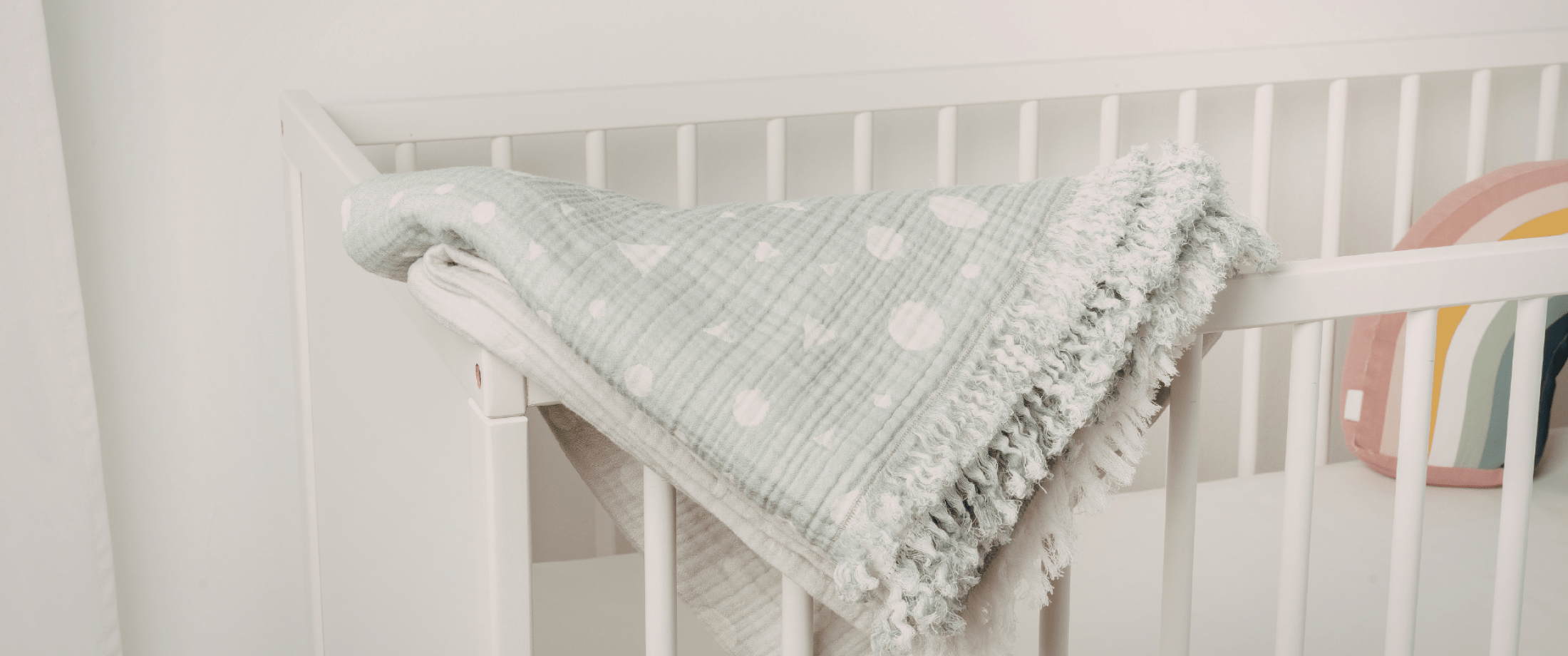 Light green baby blanket on a crib
