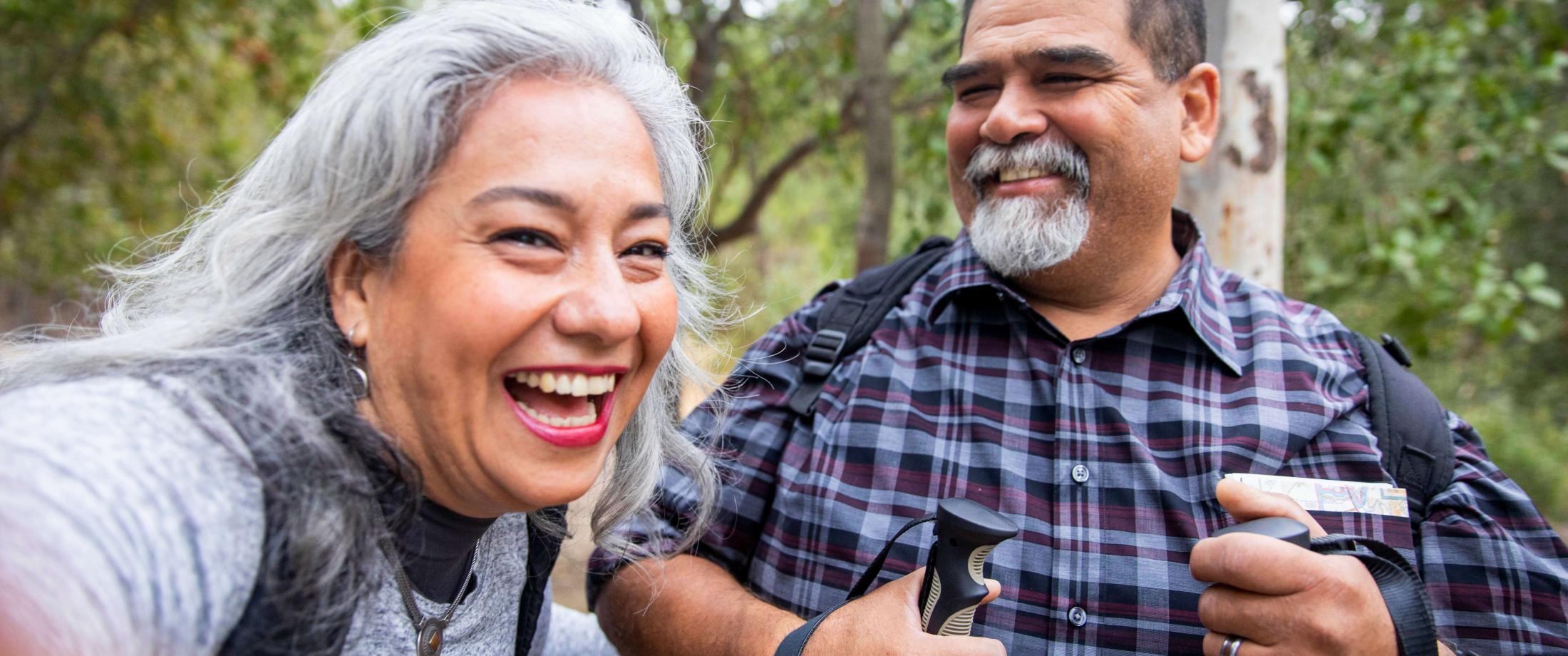 Elderly couple laughing while hiking outside