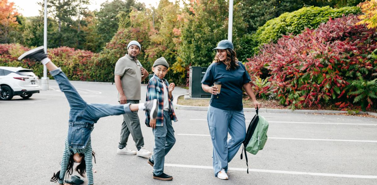 Family walking as child does cartwheel.