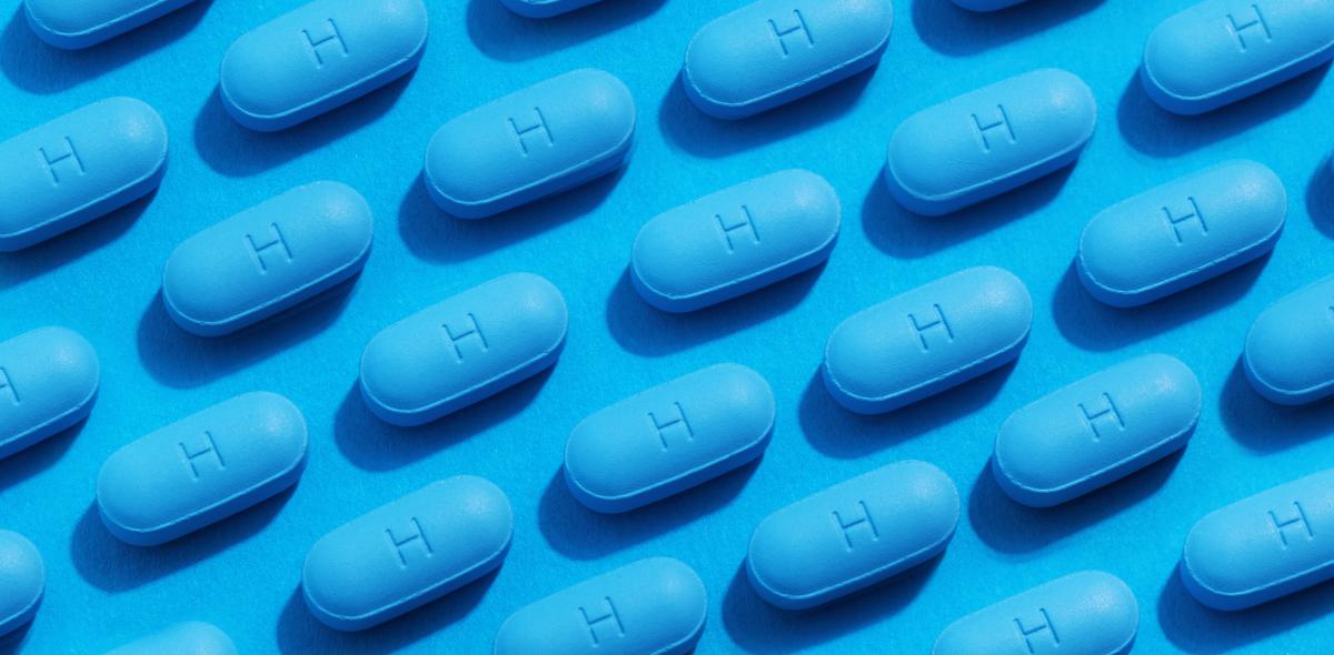 An arrangement of PrEP pills on a blue background.