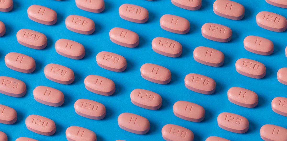A group of pink pills arranged on a blue background.