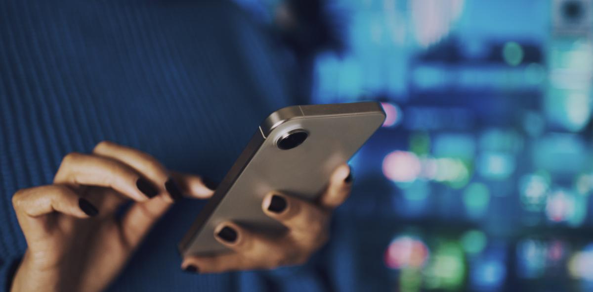 A person's hands holding a cell phone and dialing.