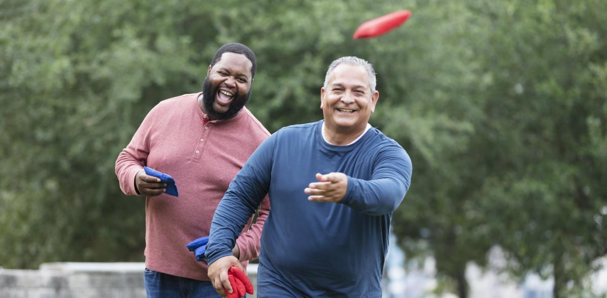 Two people playing corn hole.