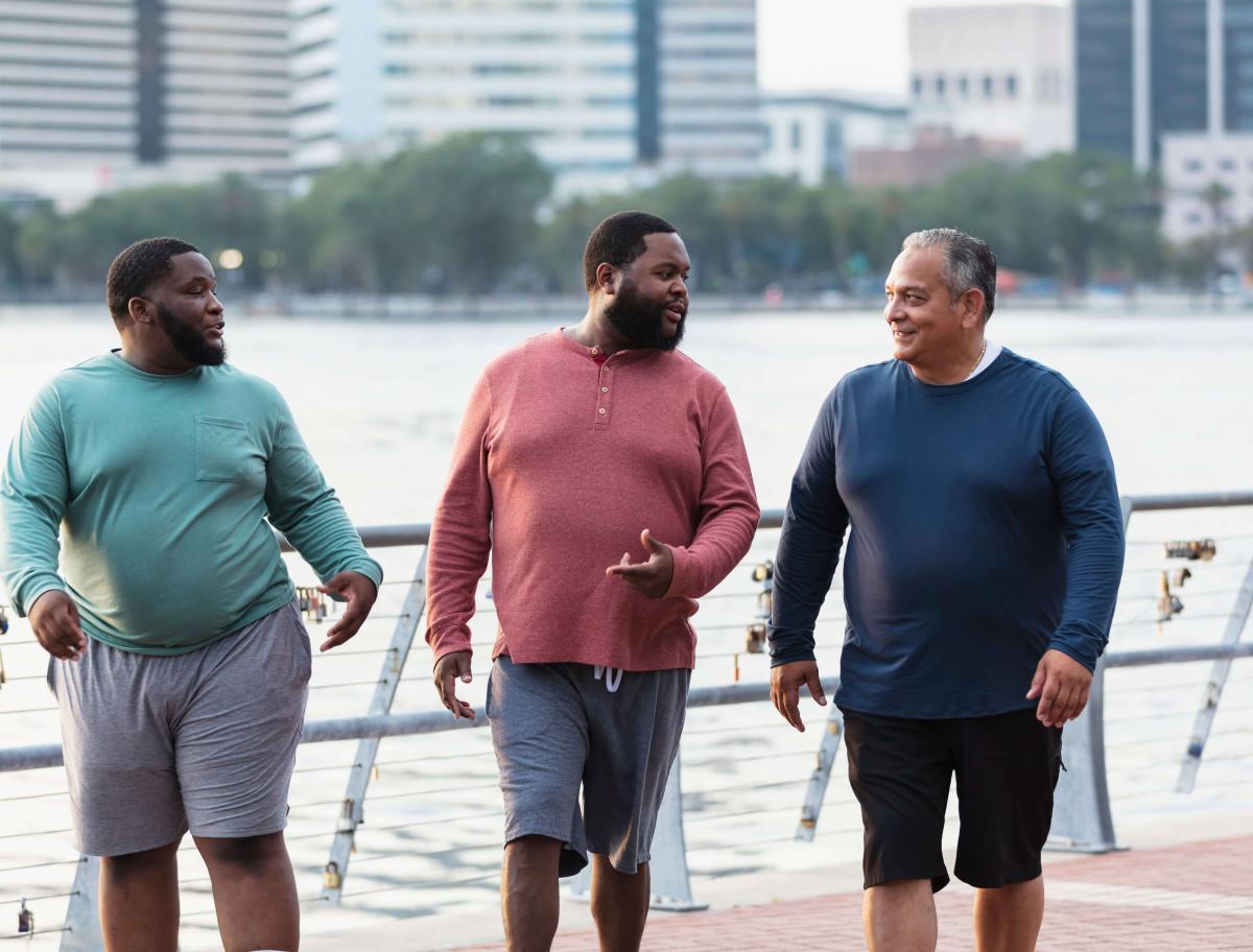 Three men walking outside in a city
