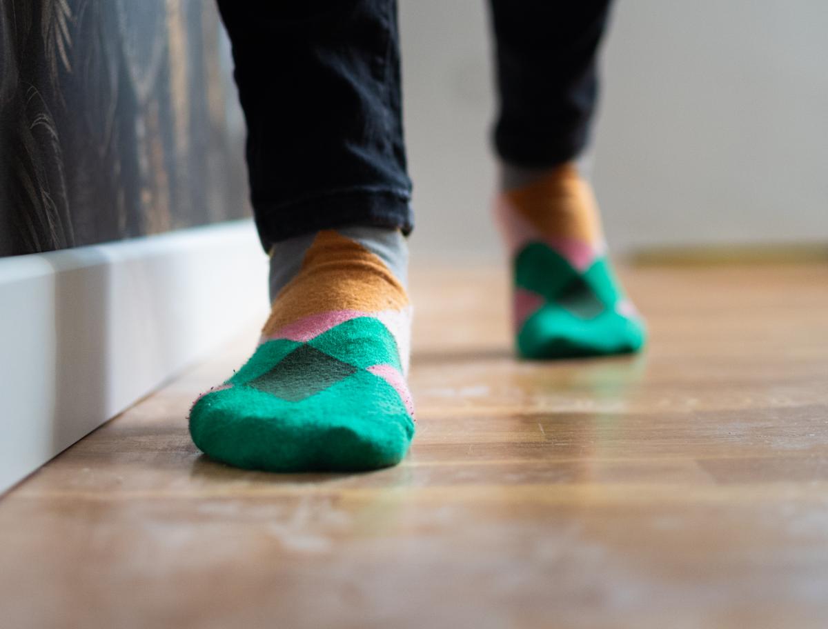 Feet in green and orange argyle socks walking toward the camera.