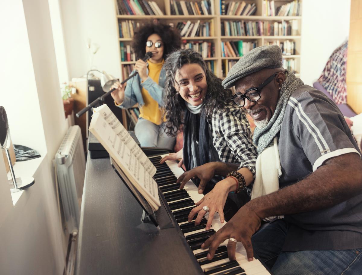 Three people playing music and laughing together.