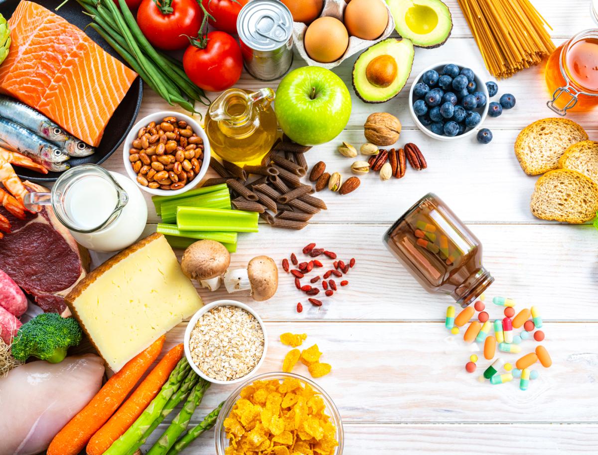 Food in a balanced diet and a few supplements on a table.