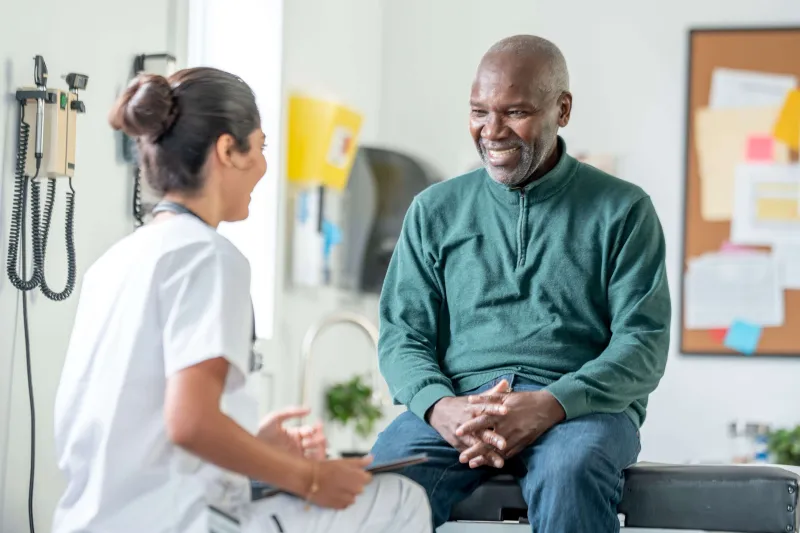 Doctor smiling and working with an older patient