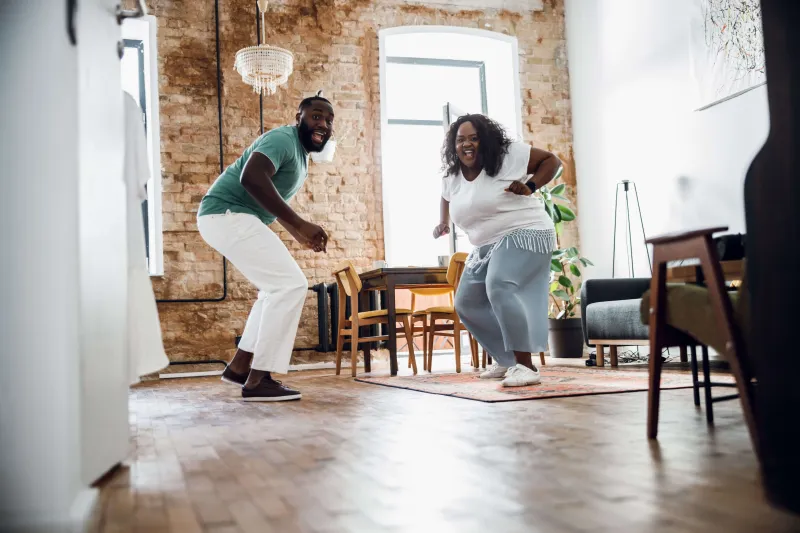 Couple happily dancing in their apartment