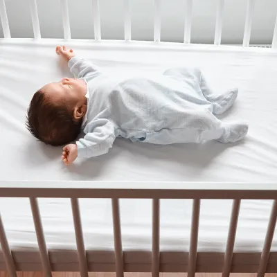 Newborn baby laying in a crib