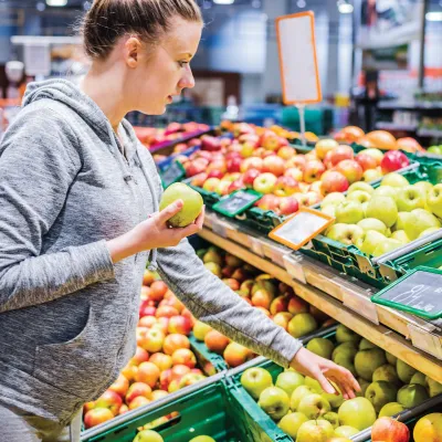Woman shopping for apples in a grocery store