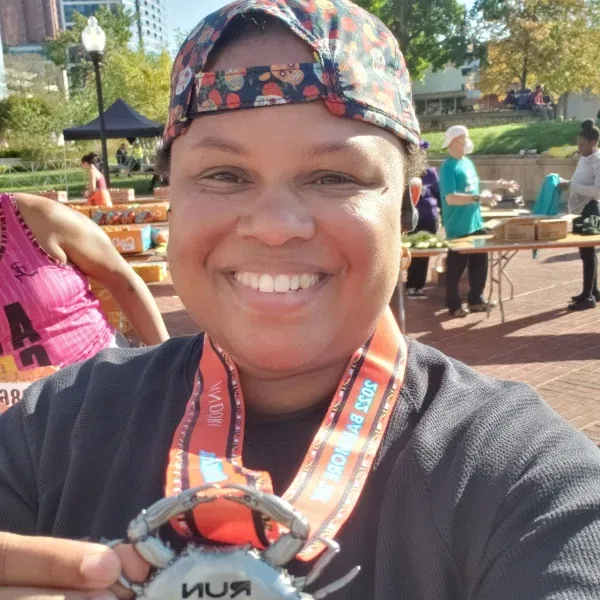 Shawnte Craig holding their running festival medal