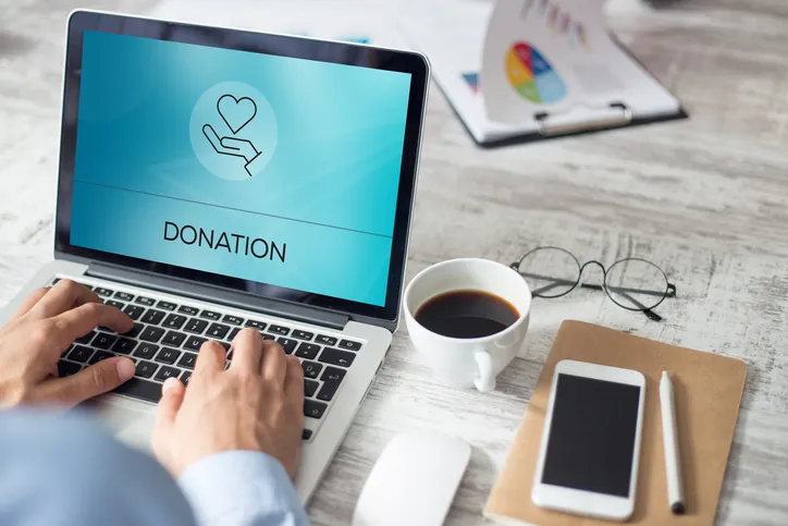 A person working on their laptop that says Donation