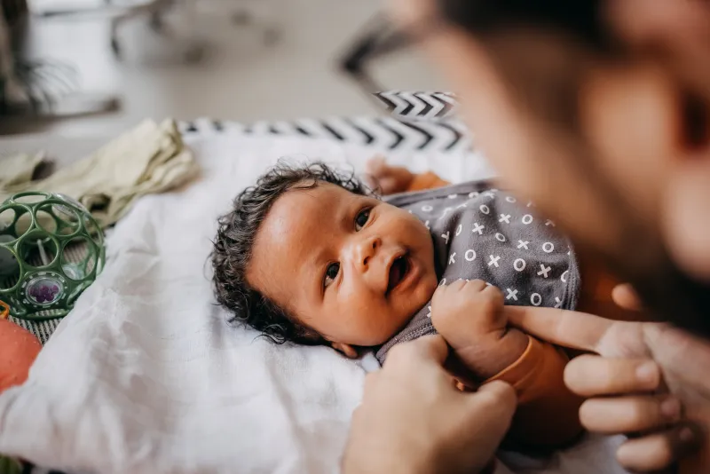 Baby holding parent's finger.