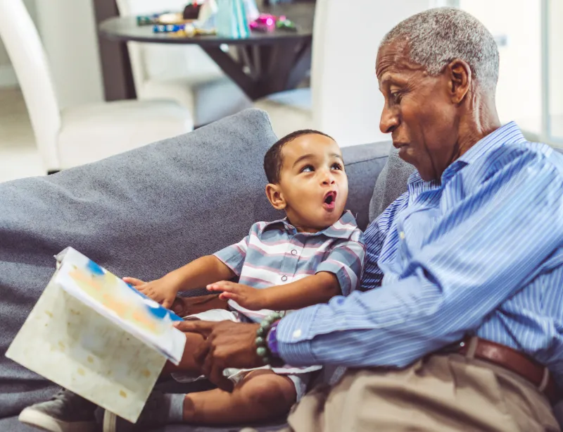 Grandfather reading to grandchild.