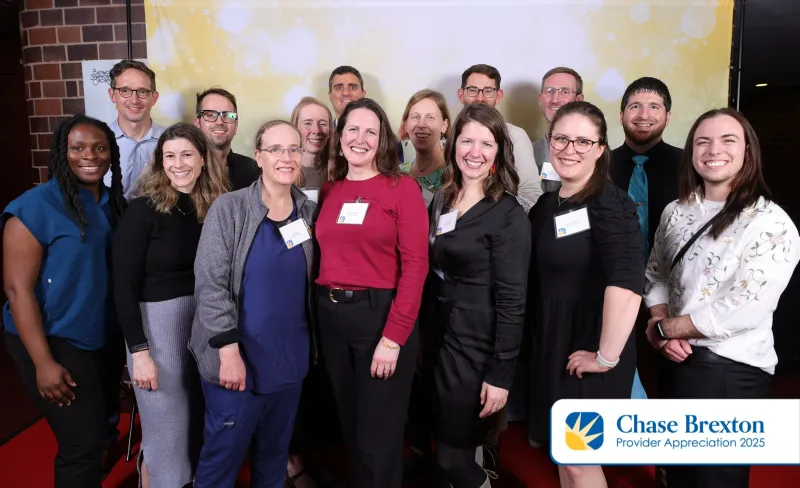 A group of people posing together in front of a backdrop during Providers Appreciation Day